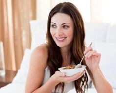 The girl eats buckwheat with porridge